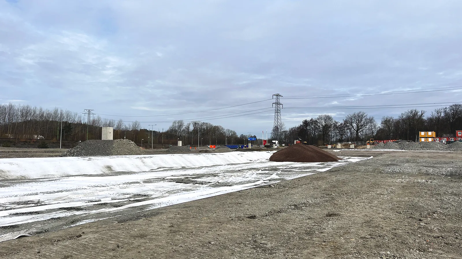 Översiktsbild av anläggningsplats med utlagd fiberduk och upplag av återbrukad lättklinker.