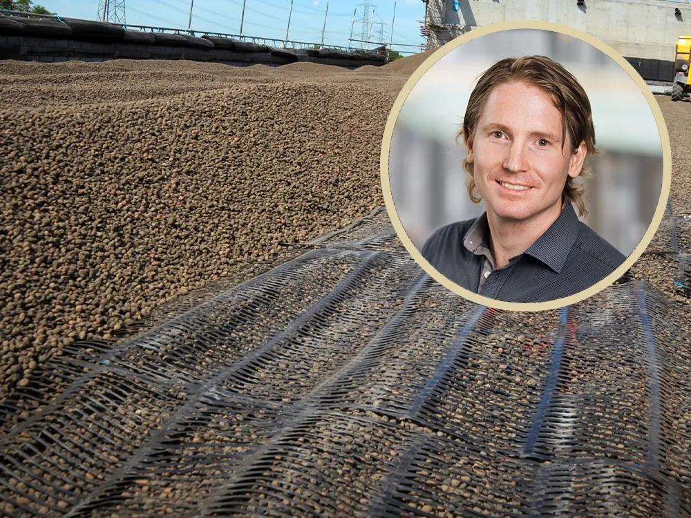 Närbild på en geokonstruktion där Leca® Lättklinker används tillsammans med geonät för att stabilisera underlaget vid ett infrastrukturprojekt. I bakgrunden syns en bro under uppförande. Infällt i bilden finns ett porträtt av en leende man i skjorta, Tomas Törnkvist