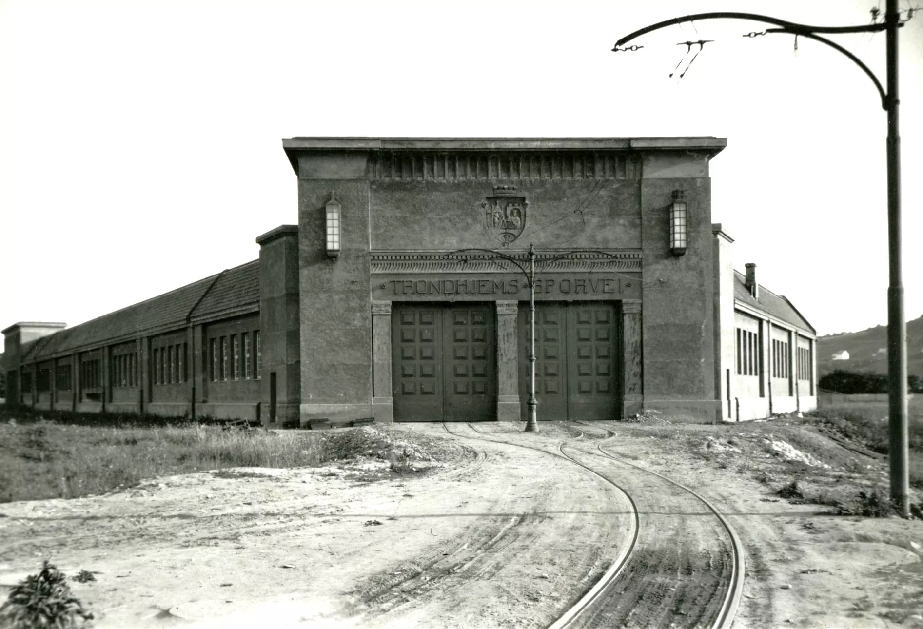 Den gamla vagnhallen vid Dalsenget i Trondheim byggdes 1923. 1956 brann stora delar av byggnaden ned tillsammans med större delen av dåvarande Trondheim Sporveis rullande materiel (foto: Trondheim stadsarkiv, fotograf okänd).
