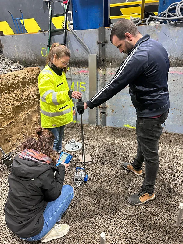Tre personer genomför mätning i Leca lättklinker med instrument för geoteknisk testning.