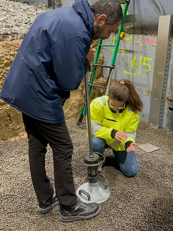 Närbild på mätutrustning som installeras i Leca lättklinker av två personer under test.